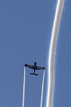 T-28B Trojan trainer aircraft performing aerobatics at airshow with smoke trails