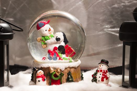 Snowman in snowdome, Christmas decoration at home, Happy New Year 2017, closeup, fake snow