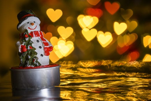 Christmas snowman and heart shaped lights in background, heart shaped bokeh blur