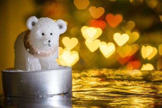 Polar bear candle and Christmas lights in shape of heart, shaped bokeh blur