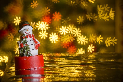 Christmas snowman and flower shaped lights in background, flower shaped bokeh blur, Christmas decoration