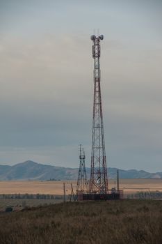 Telecommunications cell phone tower with antennas in a mountain location.