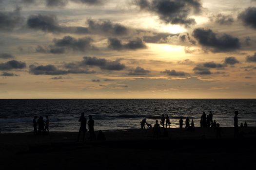 INDIA. VARKALA — MRCH 05, 2017 : Silhouettes of people watching a beautiful sunset on the beach of the Indian Ocean. Varkala town in the south of India in the state of Kerala, known for its spas.
