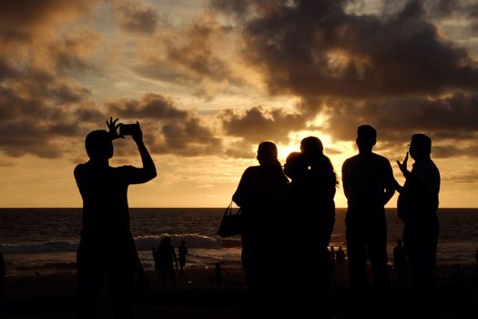 INDIA. VARKALA — MRCH 05, 2017 : Silhouettes of people watching a beautiful sunset on the beach of the Indian Ocean. Varkala town in the south of India in the state of Kerala, known for its spas.