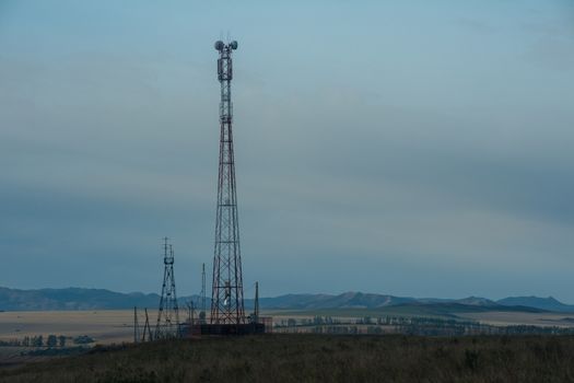 Telecommunications cell phone tower with antennas in a mountain location.