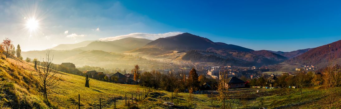 panorama of Volovets town in Carpathian mountains. gorgeous foggy sunrise with Magnificent Borzhava mountain ridge in a distance. beautiful countryside landscape in autumn