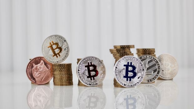 Digital currency physical bitcoins, dogecoin, litecoin and gold money on the white table. Money concept.