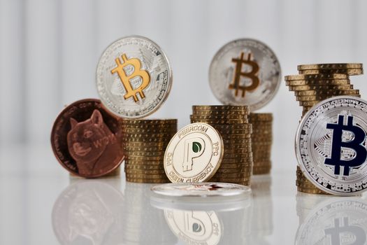 Digital currency physical gold peercooin coin near dogecoin and bitcoins.