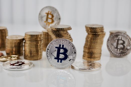 Digital currency physical silver bitcoin coin on the white table near gold money.