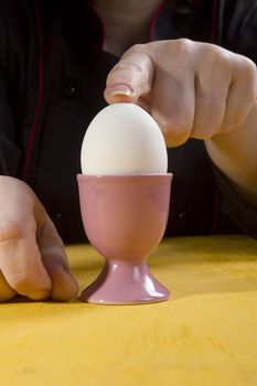 Boiled egg in the holder and the hands of the cook