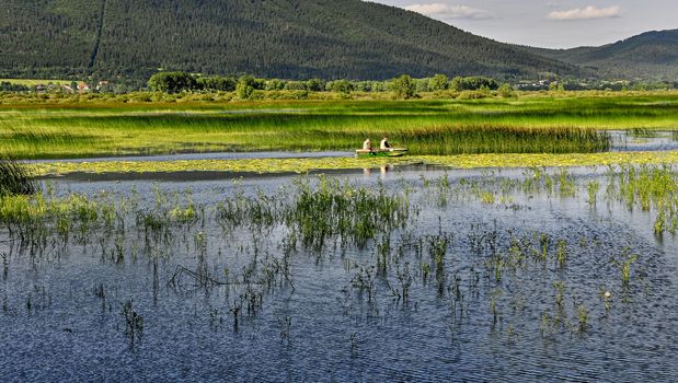 Two men in a small fishing boat on a lake