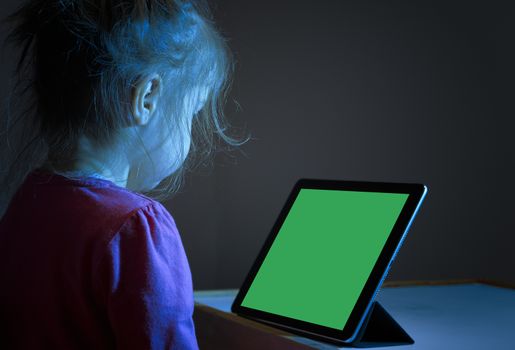 Litlle girl watching tablet PC with green screen, mock up