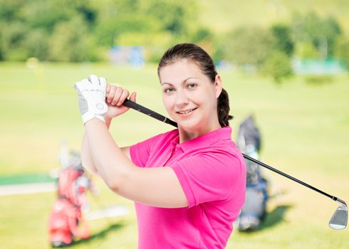 happy girl in a pink shirt on a background of golf courses