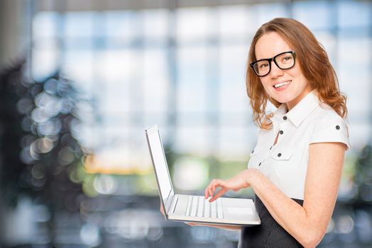 beautiful slim secretary with a laptop in the office