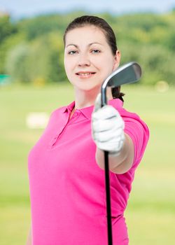 beautiful brunette golfer with a club in his hand on a background of golf courses