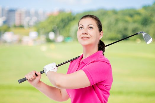 Horizontal portrait of a successful golfer with equipment for playing golf on a background of golf courses