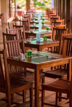 tables stand in a row on an open veranda in the tropics