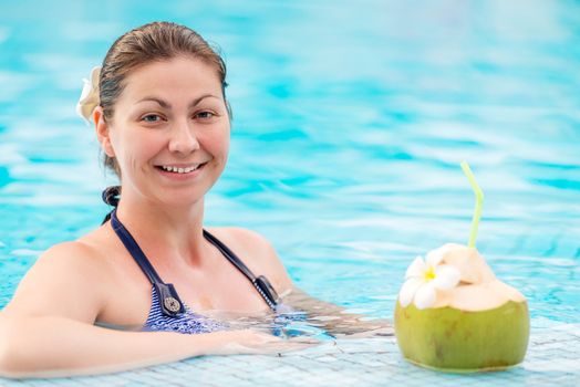 happy woman in a striped bikini and coconut with a straw