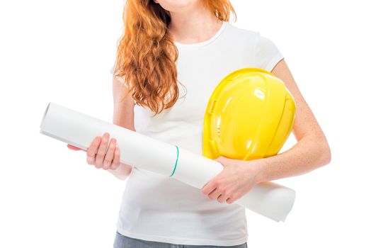 A yellow hard hat and projects on paper in the hands of a close-up woman