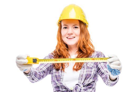 girl carpenter on a white background with a tape measure in hands on a white background