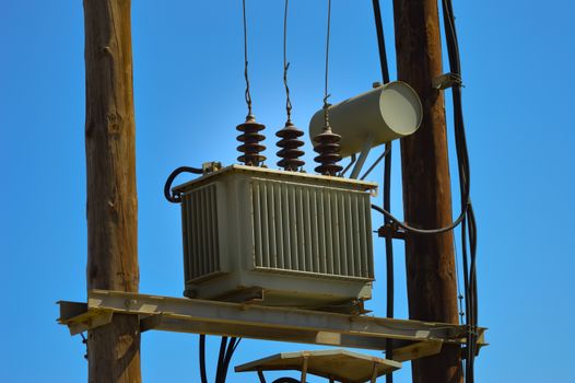 Electric transformer on wooden pylons with an arrival and several departures and countless recreations