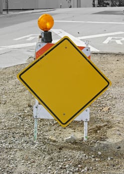 A blank yellow sign bolted onto a construction horse.