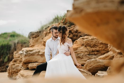 young couple groom with the bride on a sandy beach at a wedding walk