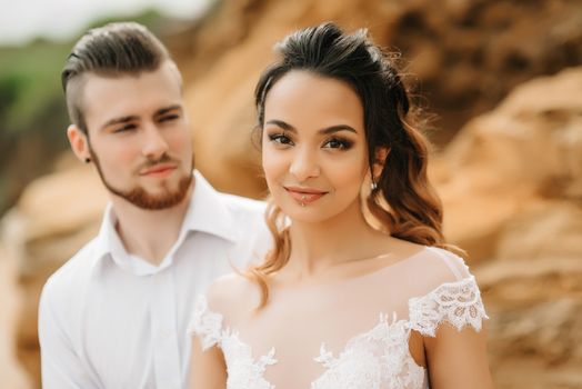 young couple groom with the bride on a sandy beach at a wedding walk