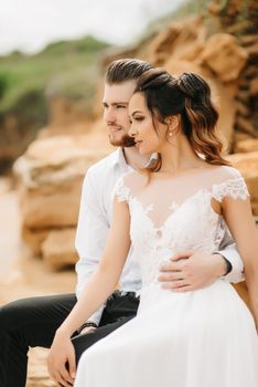 young couple groom with the bride on a sandy beach at a wedding walk