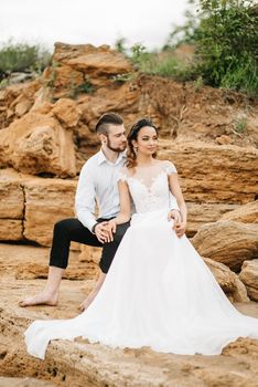 young couple groom with the bride on a sandy beach at a wedding walk