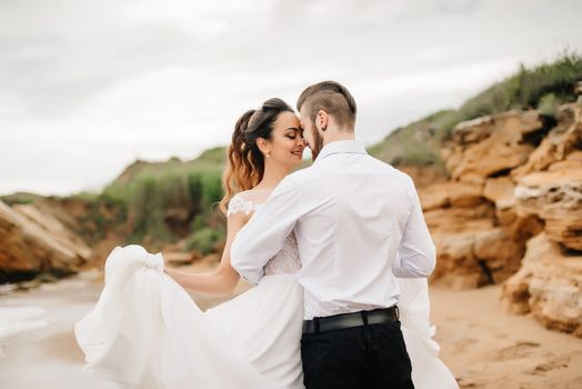 young couple groom with the bride on a sandy beach at a wedding walk