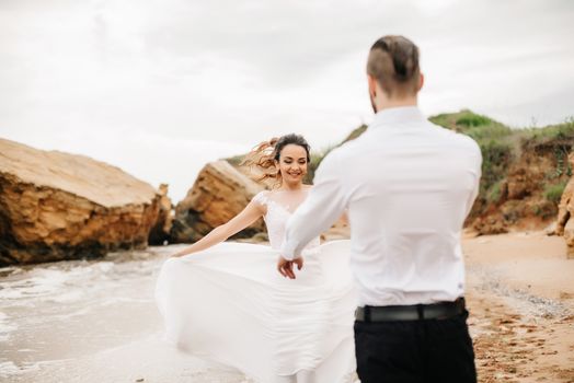 young couple groom with the bride on a sandy beach at a wedding walk