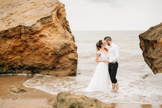 young couple groom with the bride on a sandy beach at a wedding walk