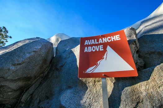 An Avalanche Above sign with rocks behind