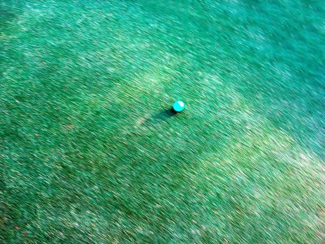 A golf ball rushing down the green