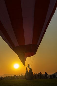 silhouette of hot air balloon on green grass in sunset time