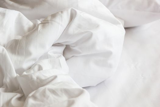 white pillow on bed and with wrinkle messy blanket in bedroom, from sleeping in a long night, details of duvet and blanket, an unmade bed in hotel bedroom with white blanket.