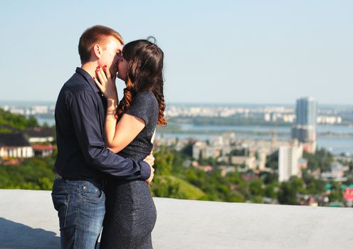 Kiss of a loving couple on the roof of a dwelling house.