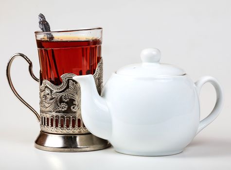 Closeup shot of teapot and glass on white background