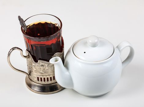 Closeup shot of teapot and glass on white background