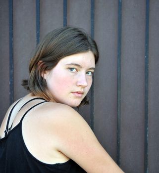 Female beauty expressions against a wall outside.