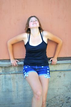 Female beauty expressions against a wall outside.