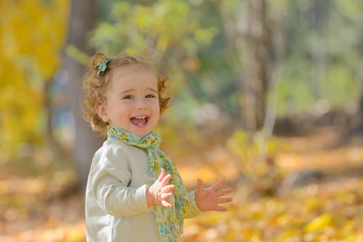 Happy little girl in autumn park