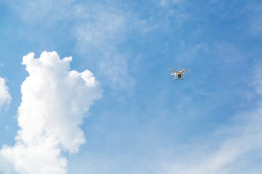 Quadcopter drone with the camera against the blue sky