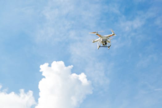 Quadcopter drone with the camera against the blue sky