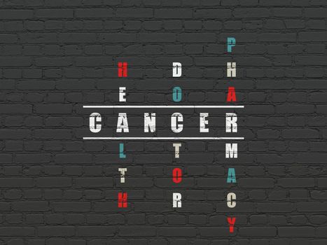 Healthcare concept: Painted white word Cancer in solving Crossword Puzzle