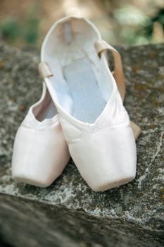 Pink pointe shoes for a classical ballerina, close-up on concrete