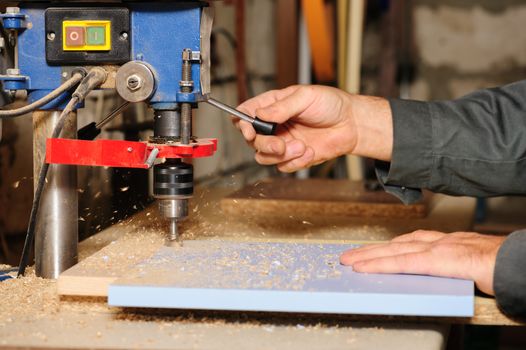 worker hands using wood milling cutter machine on laminated chipboard