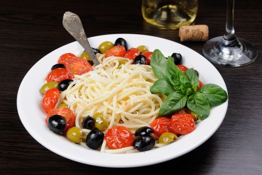 Spaghetti with olives, cherry tomatoes, sprinkled   Parmesan and basil