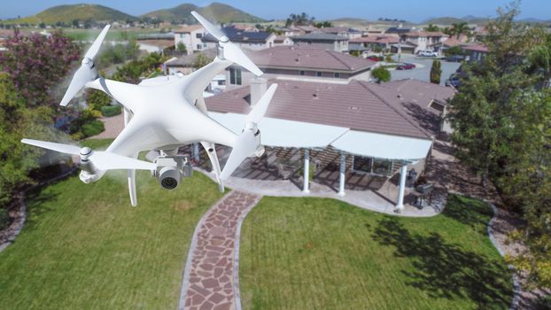 Unmanned Aircraft System (UAV) Quadcopter Drone In The Air Over House.